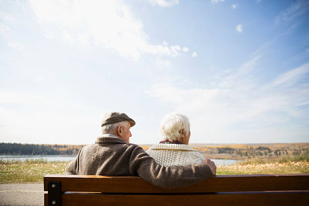 Couple de personnes âgées assis sur un banc et regardant au loin le paysage