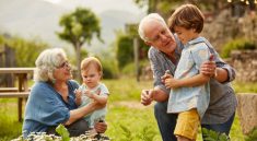 Couple de grands-parents qui jouent de le jardin avec leurs petits-enfants