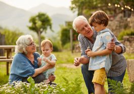 Couple de grands-parents qui jouent de le jardin avec leurs petits-enfants