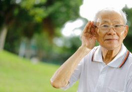 Personne âgée souffrant de presbyacousie qui porte la main à son oreille pour mieux entendre