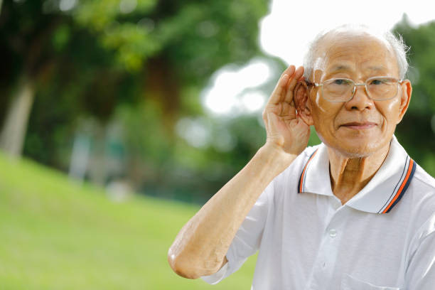 Personne âgée souffrant de presbyacousie qui porte la main à son oreille pour mieux entendre
