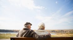 Couple de personnes âgées assis sur un banc et regardant au loin le paysage