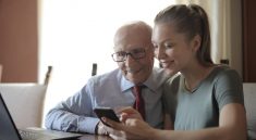 Femme qui montre son smartphone à un vieil homme