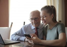 Femme qui montre son smartphone à un vieil homme